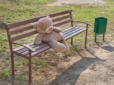 The big toy bear sitting on the bench alone. Longliess concept.の写真素材