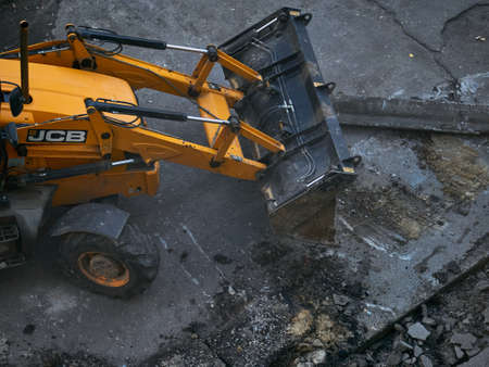 KHARKOV, UKRAINE - MAY 2020. Hydraulic Excavator Removing Remains of asphalt. Road reconstruction, pavement repair.のeditorial素材