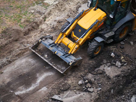 Photo pour Hydraulic Excavator Removing Remains of asphalt. Road reconstruction, pavement repair - image libre de droit