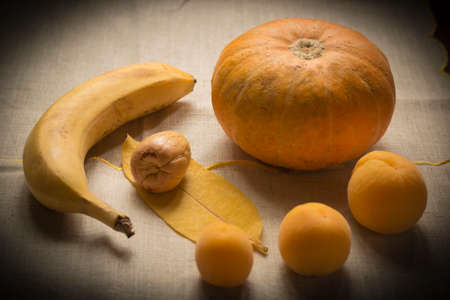 A still life of similar-colored yellow and orange vegetables and fruits arranged in the shape of a circleの写真素材