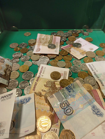 Russian money. Banknotes and scattered coins mixed up on a green cloth.