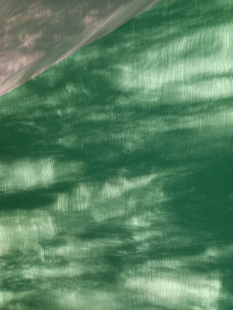 Photo background of mint green shade with a white corner on top, illuminated by the rays of the sun