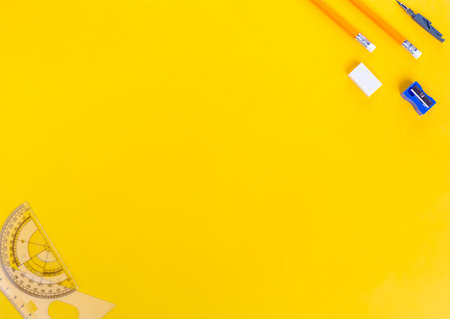 Yellow background with rowan berries and stationery. The concept of "Back to School". Pencils, eraser, sharpener, compasses, rulers and rowan berries. view from above. Space for text. mockup.の写真素材