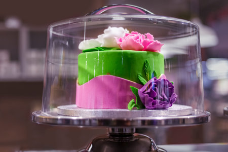 Elite cake decorated with flowers in a glass confectionery showcase