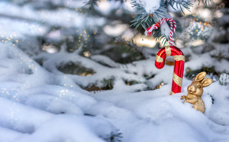 Christmas blue spruce covered with snow outdoors on a clear winter day. Decorated with a golden...