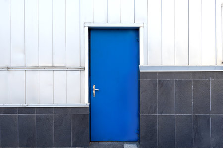 a blue door on a black and white wall. geometric composition.の写真素材