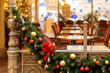 Christmas tree garland on door of cafe, interior with tablesの写真素材