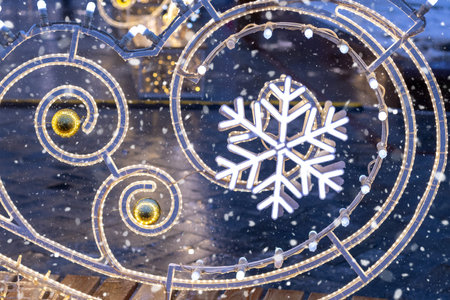 Glowing Christmas ornament. Festive illumination on streets of city. Snowflakes. Close-upの写真素材