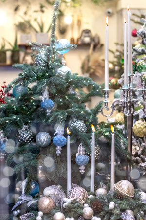 Interior with Christmas tree and burning candles in silver and cyan colors.の写真素材