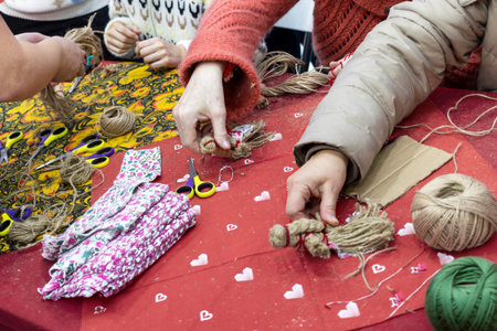 Hands of senior women engaged in handmade, making dolls from threadの写真素材
