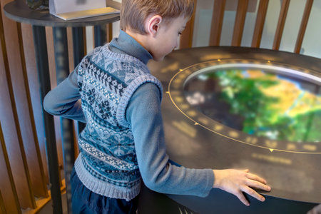 Boy interacts with a circular interactive screen at an exhibit. Like fairy taleの写真素材