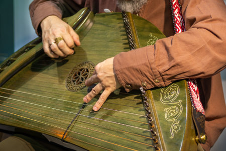 Close-up of man in vintage clothing playing traditional stringed musical instrument. Ancient psalteryの写真素材