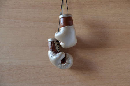 Old boxing gloves, leather boxing gloves, hanging on a wooden wallの写真素材