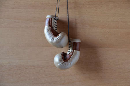 Old boxing gloves, leather boxing gloves, hanging on a wooden wallの写真素材