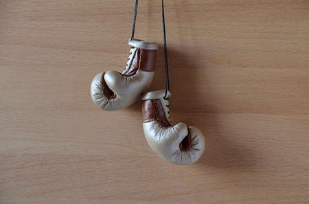 Old boxing gloves, leather boxing gloves, hanging on a wooden wallの写真素材