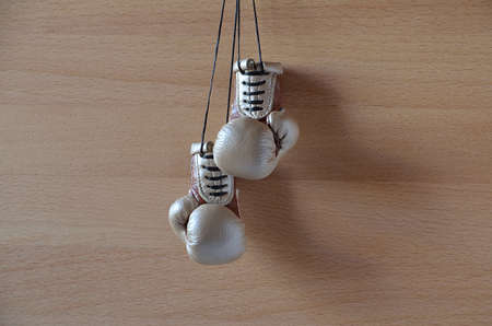Old boxing gloves, leather boxing gloves, hanging on a wooden wallの写真素材
