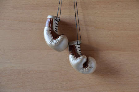 Old boxing gloves, leather boxing gloves, hanging on a wooden wallの写真素材