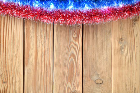 New year theme for postcards. Decorations for Christmas decorations. Wooden background with Christmas toys. Festive garland on a wooden background. Festive mood. Copy space for text.の写真素材