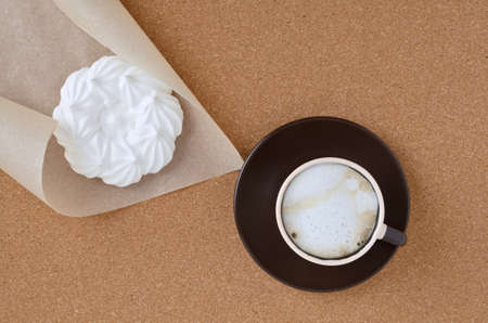 Fresh cappuccino coffee and meringue on top of the corkboard.の写真素材