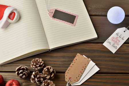 Christmas decorations, star and balls on wooden table. Notebook for new year greetings. Festive decoration, on a brown wooden table with space for text.の写真素材