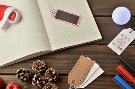 Christmas decorations, star and balls on wooden table. Notebook for new year greetings. Festive decoration, on a brown wooden table with space for text.の写真素材