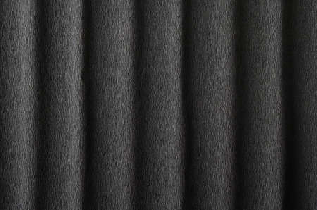 Black crepe paper background with vertical waves and a small pattern for your creative tasks.の写真素材