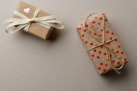 Gift boxes in crafting for Valentine's Day on a cardboard beige background with space for your creativity and space for text.の写真素材