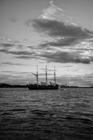 Sailing boat in the lake at sunset. Black and white photo. Lake Ontario, Canada.