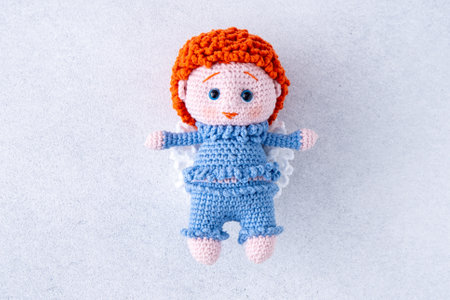 Knitted childrens toy. Boy angel in a blue suit. Crochet.の写真素材