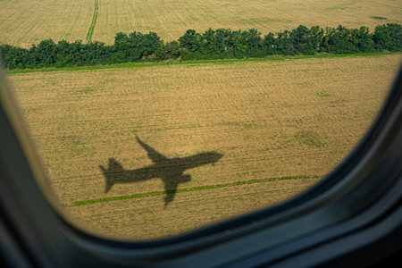 Plane. View from the airplane window. The shadow of an airplane on a yellow field of sunflowers. Situet. View from above. Travel concept. Portholeの写真素材