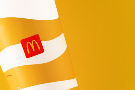 Yellow glass of McDonalds. Paper cup with lid. Takeaway drink. McDonalds logo. Ukrainian, Kyiv - March 02, 2023.のeditorial素材