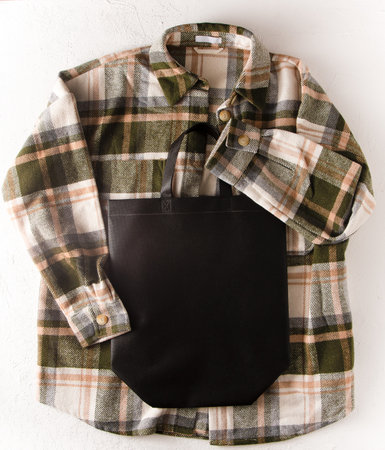 Black eco shopping bag with place for text. Bag mock up template top view. Wardrobe with shirt and boots. Clothes and accessories.の写真素材