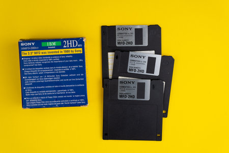 Ukraine, Kyiv - February 7, 2021: SONY Floppy disk 3.5 inch. The diskettes 3 2 are a technology icons of de decade of 80s. Retro, vintage computer diskette. Yellow backgroundのeditorial素材