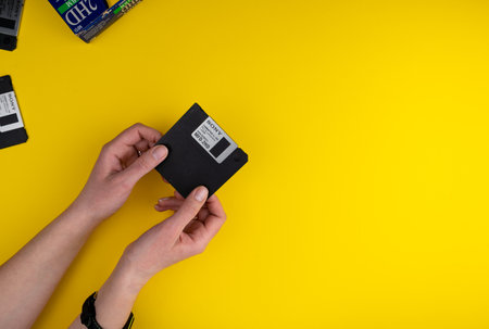 Ukraine, Kyiv - February 7, 2021: SONY Floppy disk 3.5 inch. The diskettes 3 2 are a technology icons of de decade of 80s. Retro, vintage computer diskette. Yellow backgroundのeditorial素材