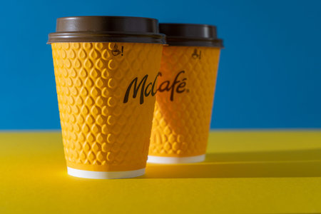Ukraine, Kyiv - February 17, 2021: Yellow glass of coffee from McDonalds. Paper glass drink McCafe....