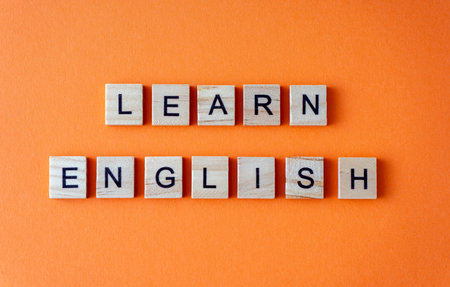 Word learn English. Motivation. The phrase is laid out in wooden letters top view. Motivation....