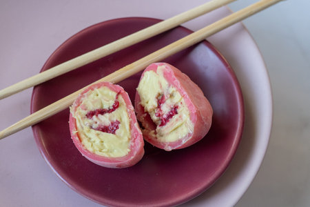 Pink mochi dessert with cream filling and berry. Sweet food