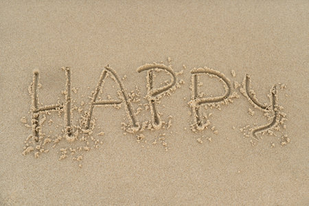 Happy concept - inscription in the sand. Sandy coast of the sea. Motivation. The word happy time is written on the sea beach. Vacations on the shore.の写真素材