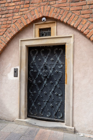 Old doors in the house. Entrance to the building. Forged metal gratings. Poland, Warsaw - July 27, 2023のeditorial素材
