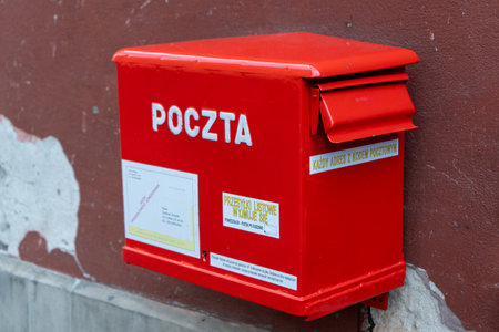 Polish red mailbox on the street. Box for letters and correspondence. Warsaw, Poland - July 23, 2023.のeditorial素材