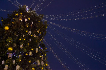 Street city Christmas tree at night. The garlands are lit. Holiday decorations and toys. Garland of lights.の写真素材