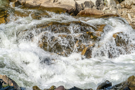Mountain river. Flow of water over stones. Cascades.