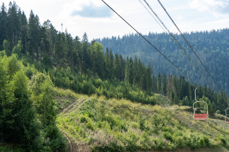 Ski lift in green forest. Cableway in Mountains. Summer nature.の写真素材