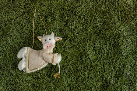 Cow soft toy decoration. Christmas tree toy with green needles in the backgroundの写真素材