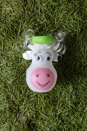 Cow glass ball toy decoration. Green needles in the backgroundの写真素材