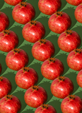 Pomegranate pattern. Red pomegranates on a green background. Fruit food.の写真素材