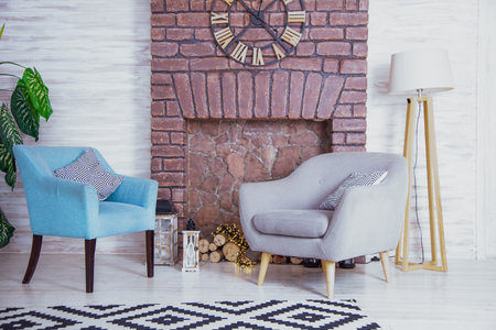 Comfortable reading chair in the room near the fireplace. Furniture of different styles. Relax and rest home background. Aesthetic Interior.の写真素材