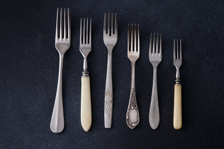 Forks on a black background. Set of old different cutlery for food.の写真素材