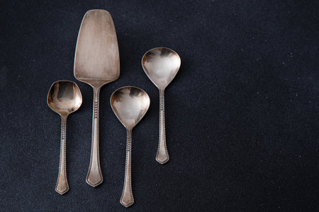 Elegant Silver Serving Utensils Set. Different spoons cutlery on a black background.の写真素材
