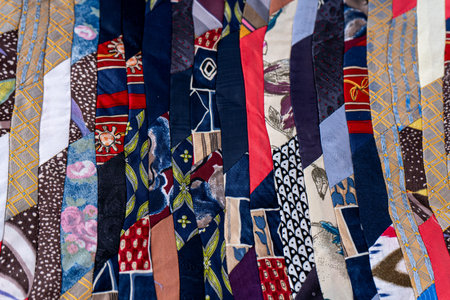 Patchwork Quilt Made of Repurposed Neckties. A fragment of multi-colored pieces of fabric sewn...